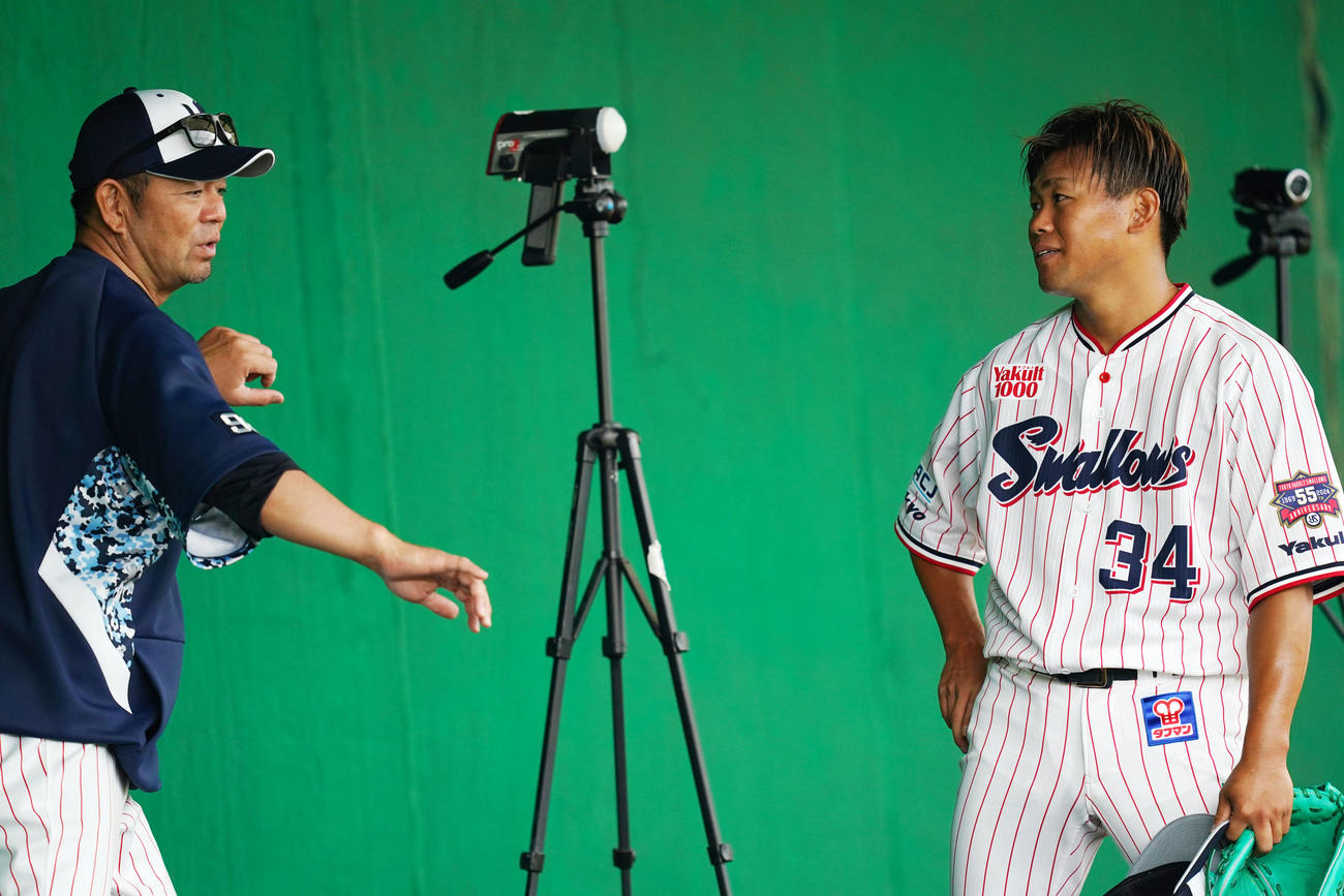 ブルペンでの投球練習を終えヤクルト石井コーチ（左）と言葉を交わす田口（撮影・横山健太）