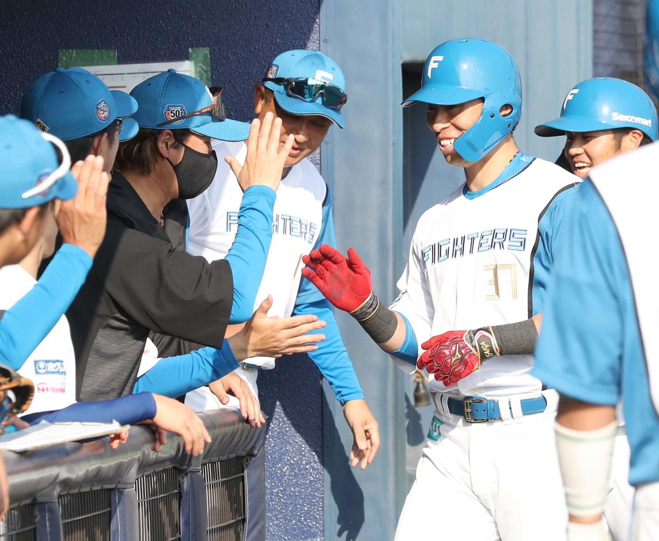 日本ハム対楽天　8回裏日本ハム無死一塁、2点本塁打を放った江越（右から2人目）は新庄監督（同4人目）に出迎えられる（撮影・黒川智章）
