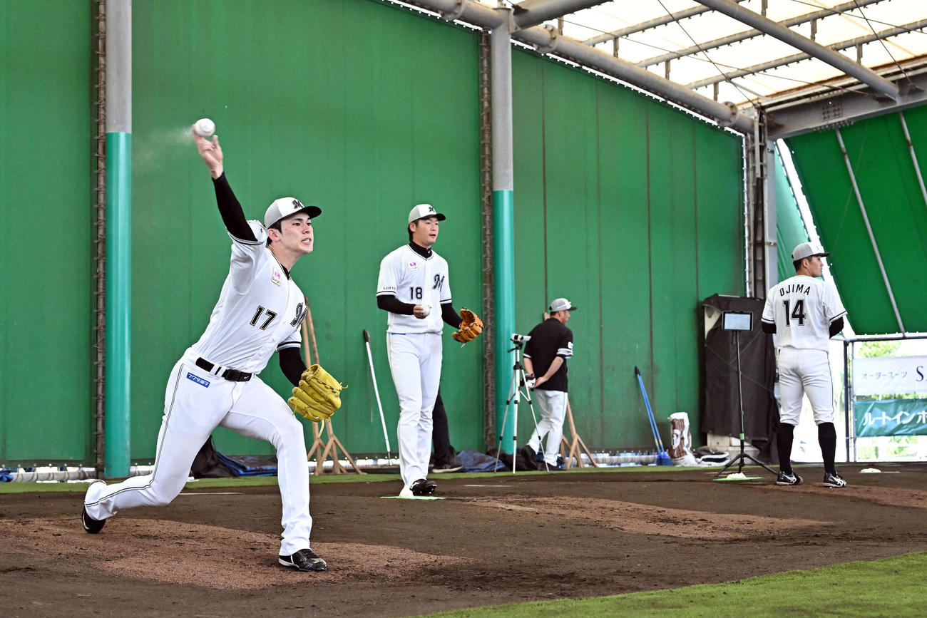ブルペンで投球練習するロッテ佐々木（左）。左から2人目は二木。右は小島（撮影・滝沢徹郎）