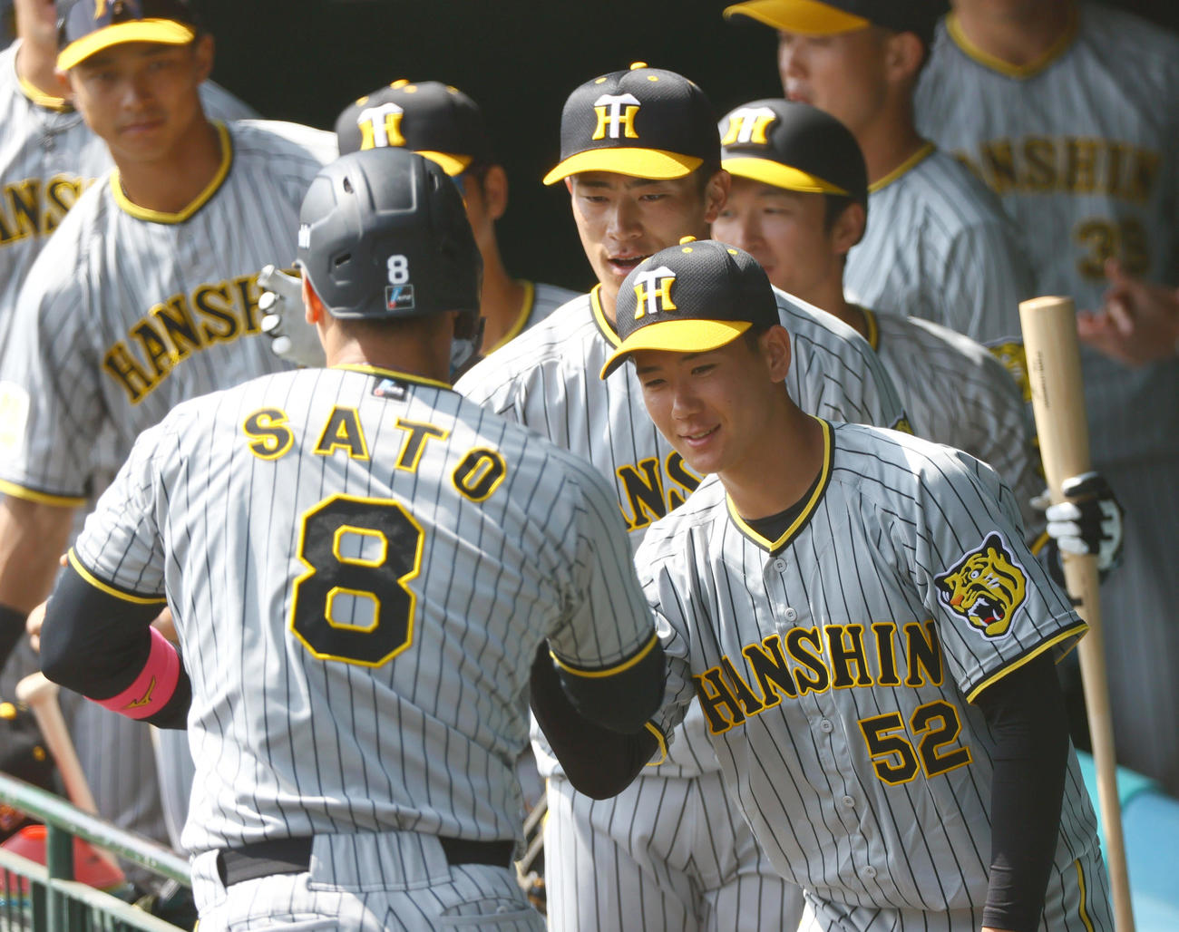 紅白戦　1回表紅組1死一、三塁、中野拓夢の時、相手失策で生還した佐藤輝（手前）を出迎える山田（右）ら（撮影・上山淳一）