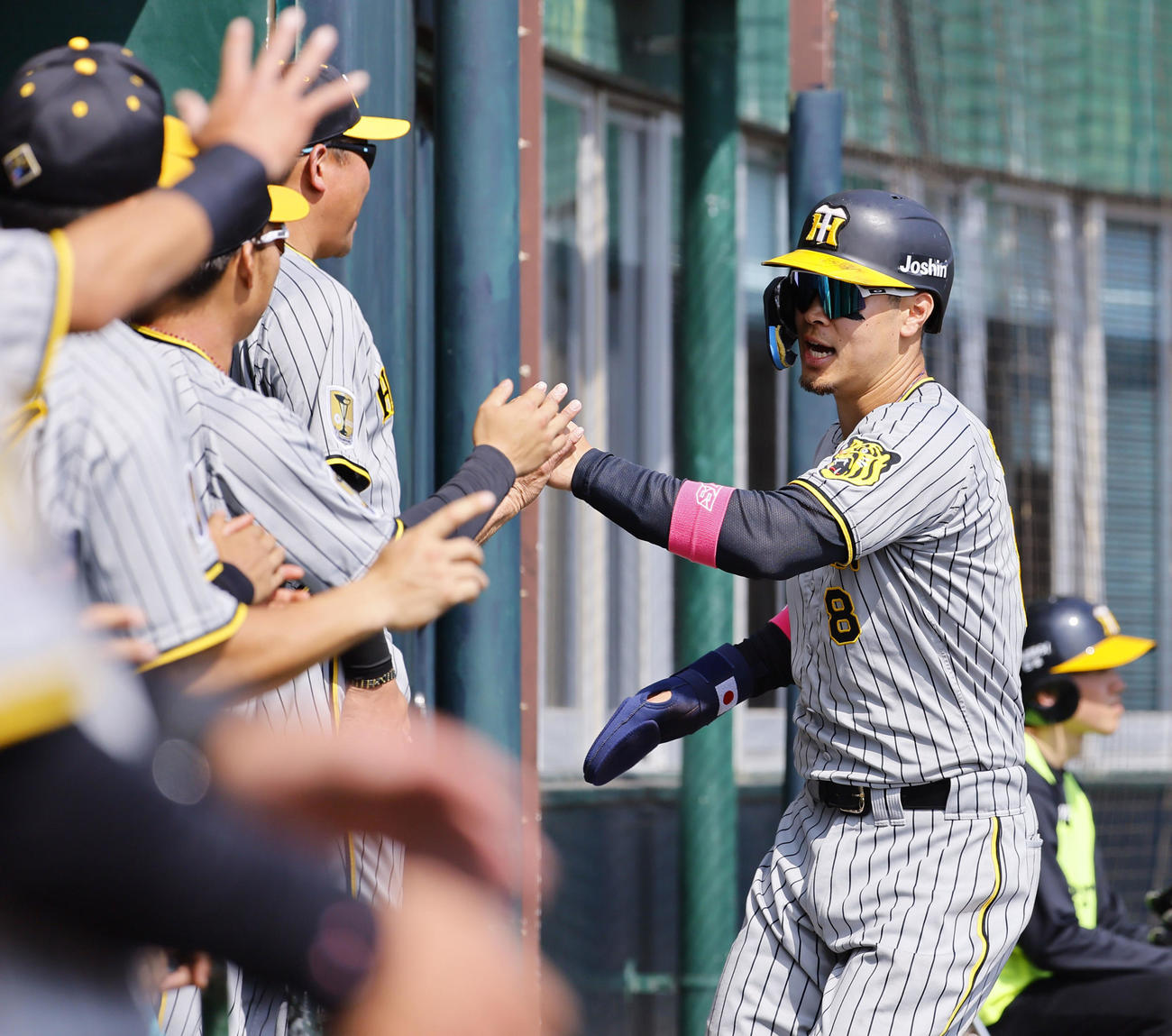 紅白戦　3回表紅組無死一、二塁、野口の適時打で生還し、ナインとタッチを交わす佐藤輝（撮影・藤尾明華）