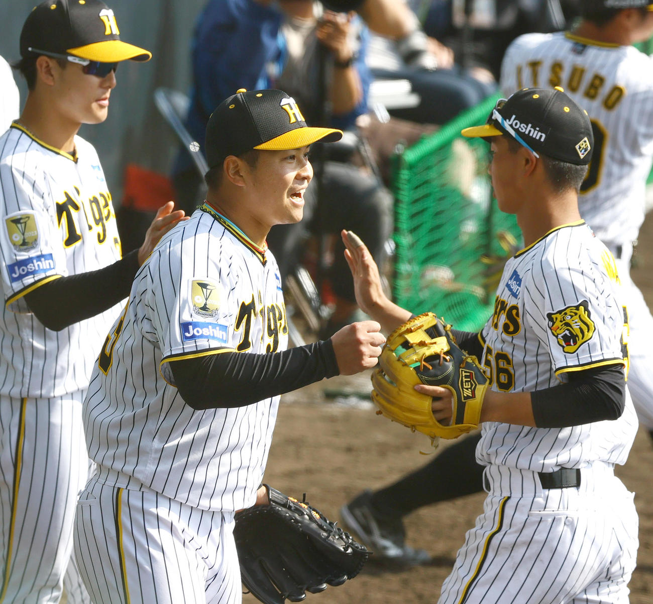 紅白戦　7回に登板した白組の松原（中央）は三者凡退に仕留めベンチ前でナインを出迎える（撮影・上山淳一）