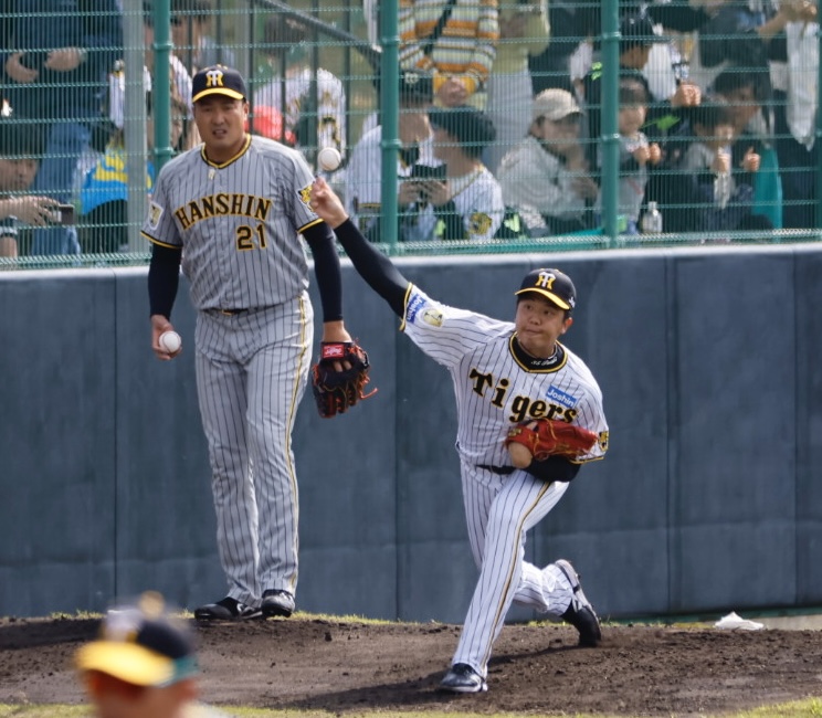 阪神春季キャンプ紅白戦　投球練習する先発した白組才木（右）と紅組先発秋山（撮影・藤尾明華）