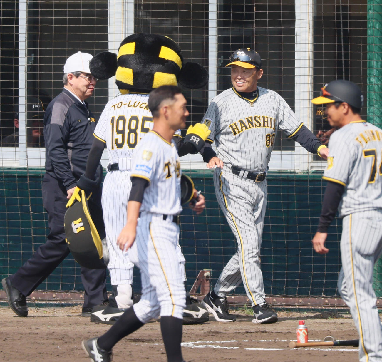 紅白戦　4回を終えベンチへ引き揚げる岡田監督（右）はトラッキーと笑顔でタッチ。左は杉山オーナー（撮影・加藤哉）