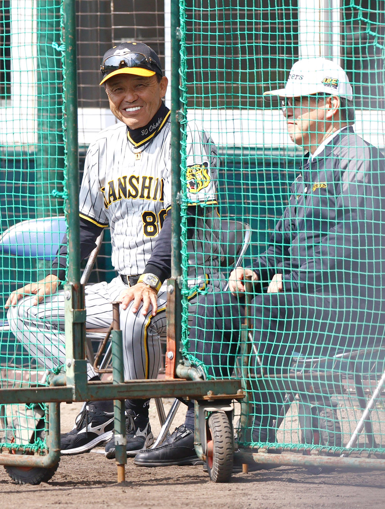 紅白戦　ネット裏から笑顔を見せる阪神岡田監督（左）と杉山オーナー（撮影・上山淳一）