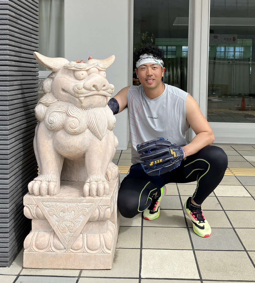 自主トレ後、室内練習場前のシーサーと写真に納まるDeNA松本凌（撮影・久保賢吾）