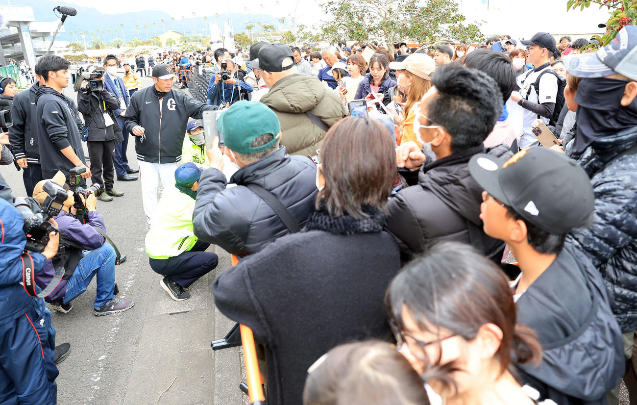 宮崎キャンプ打ち上げで大勢のファンにサインする巨人阿部監督（左）（撮影・浅見桂子）