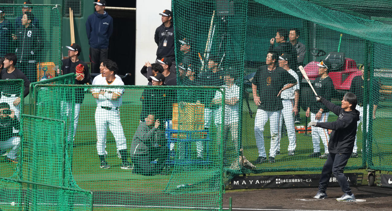 岡本和（左）ら巨人ナインが見守る中、フリー打撃で柵越えを披露する松井臨時コーチ（撮影・鈴木みどり）