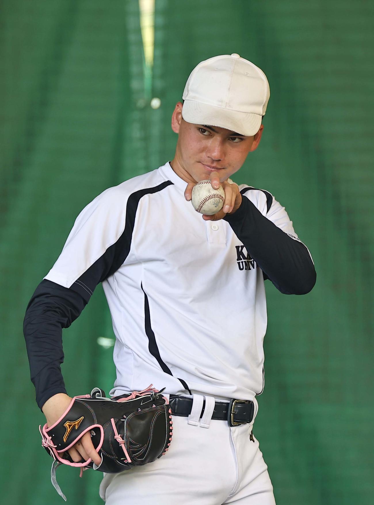 ブルペンでスプリットの握りを見せる関大・金丸（撮影・上田博志