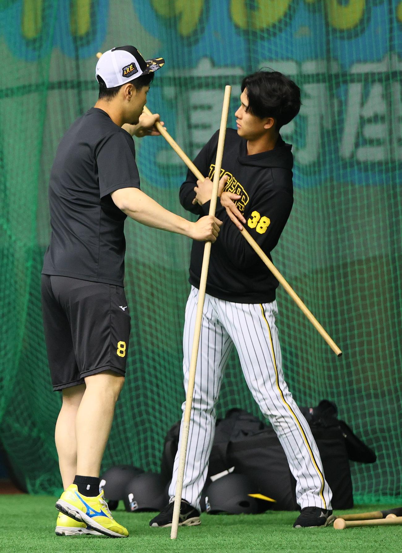阪神佐藤輝（左）は小幡に打撃のアドバイスする（撮影・上山淳一）