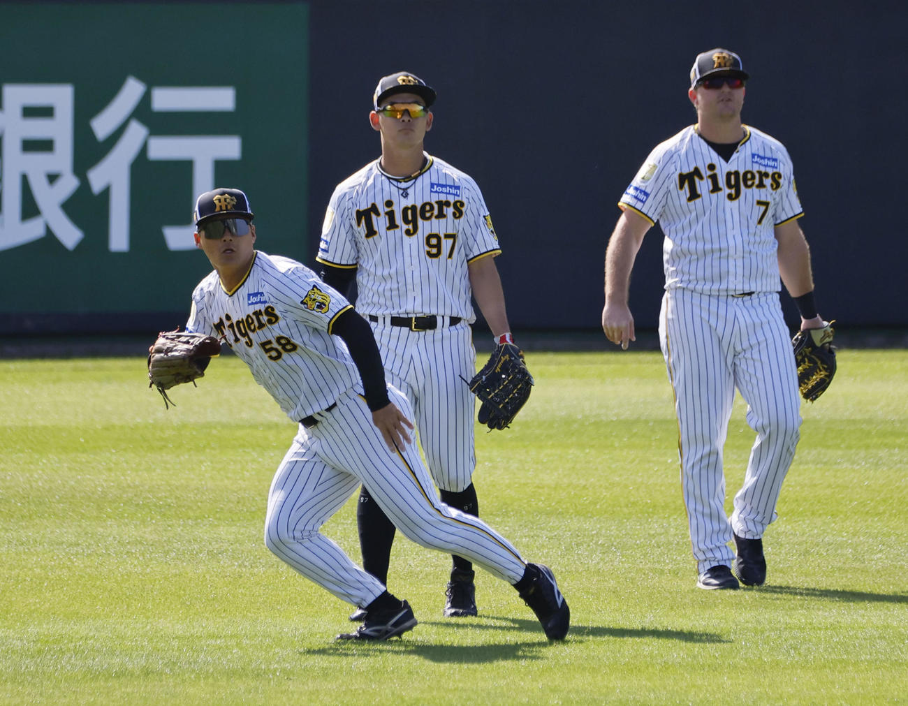 シートノックで左翼を守る前川（左）と井上（中央）、ノイジー（撮影・藤尾明華）