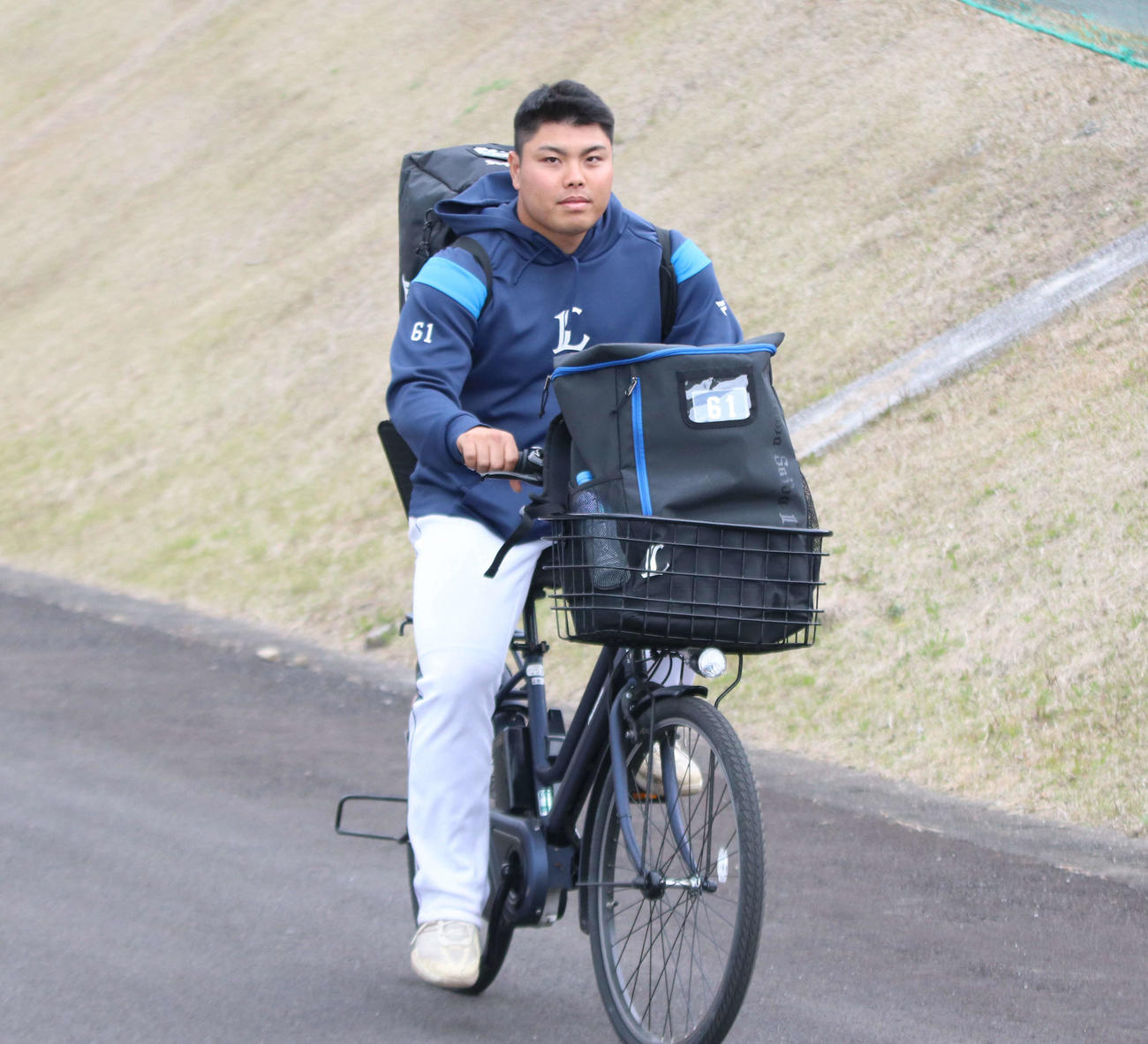自転車で移動する西武平良（撮影・山崎純一）