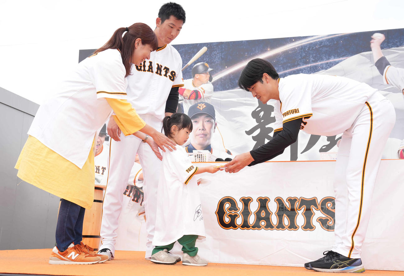 バレンタインイベントで子供にチョコを渡す巨人西舘（右）。左上は戸郷（撮影・鈴木みどり）
