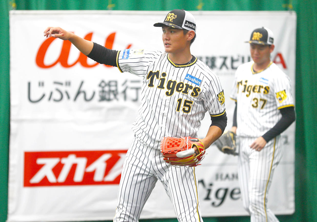ブルペンで投球する阪神西純。奥は及川（撮影・上山淳一）