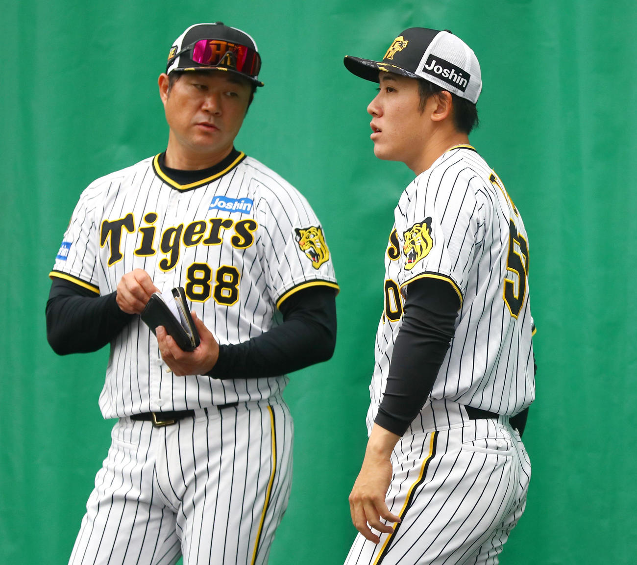 ブルペンで阪神富田（右）は安藤投手コーチの話を聞く（撮影・上山淳一）