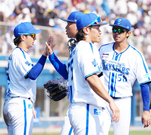 DeNA対日本ハム 7回表終了後、DeNA度会(左)とタッチを交わす4番手の松本凌(撮影・江口和貴)