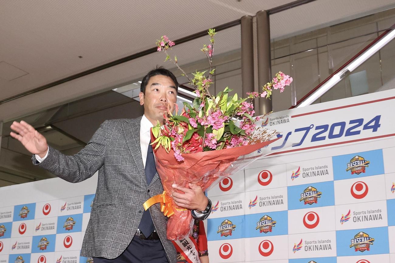 那覇入りし、歓迎セレモニーで花束を受け取り、ファンの声援に応えながら移動する巨人阿部慎之助監督（撮影・河田真司）
