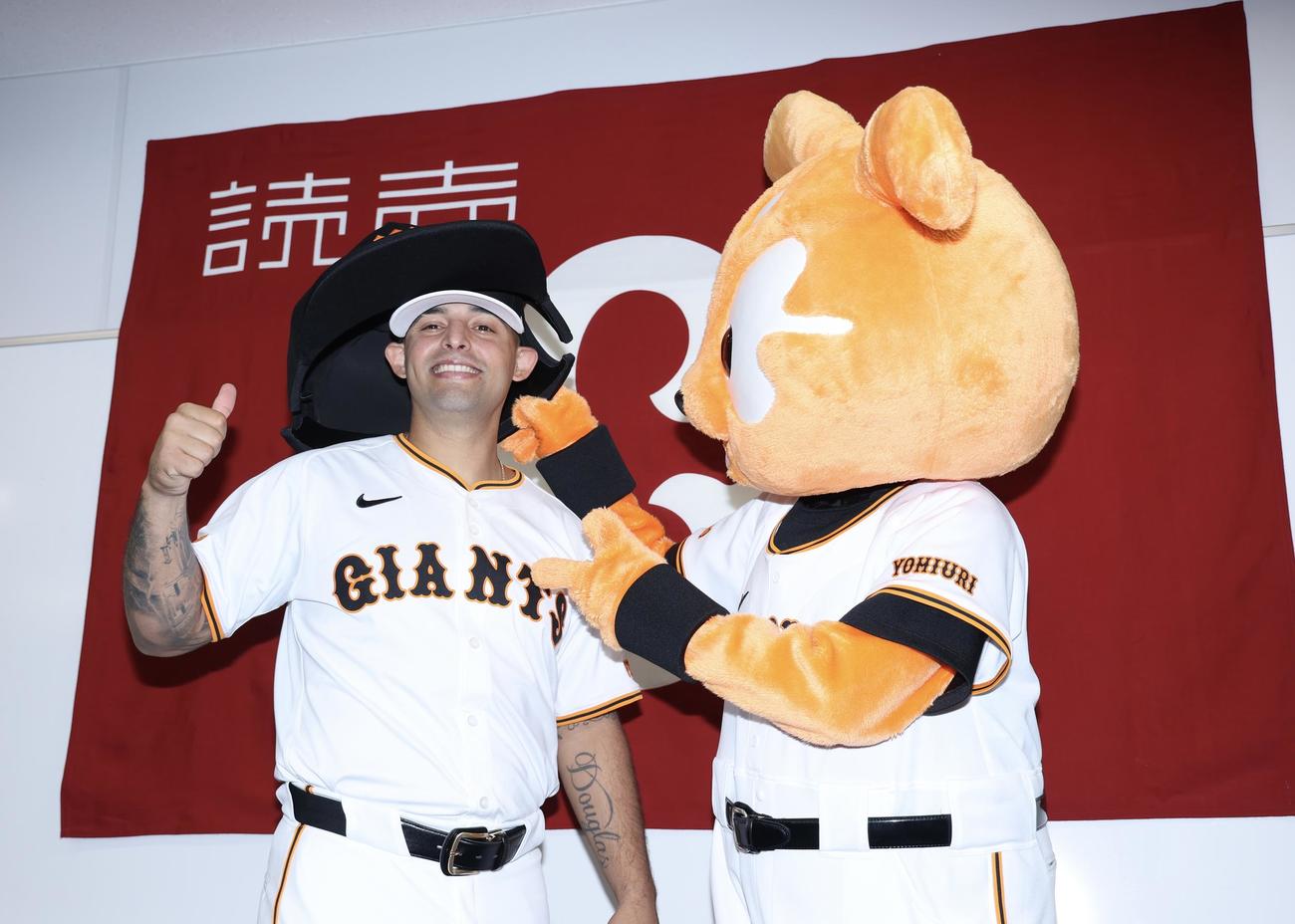 入団会見で、ジャビット（右）に巨大な帽子を被せてもらいながら写真に納まる巨人オドーア（撮影・河田真司）