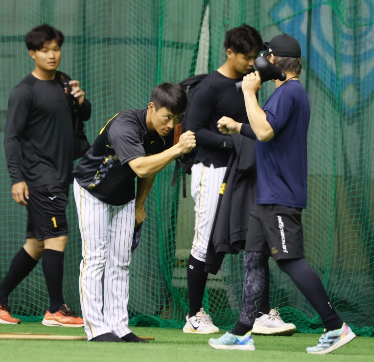 阪神春季キャンプ1軍に合流した福島（左から2人目）は梅野隆太郎とグータッチを交わす（撮影・藤尾明華）