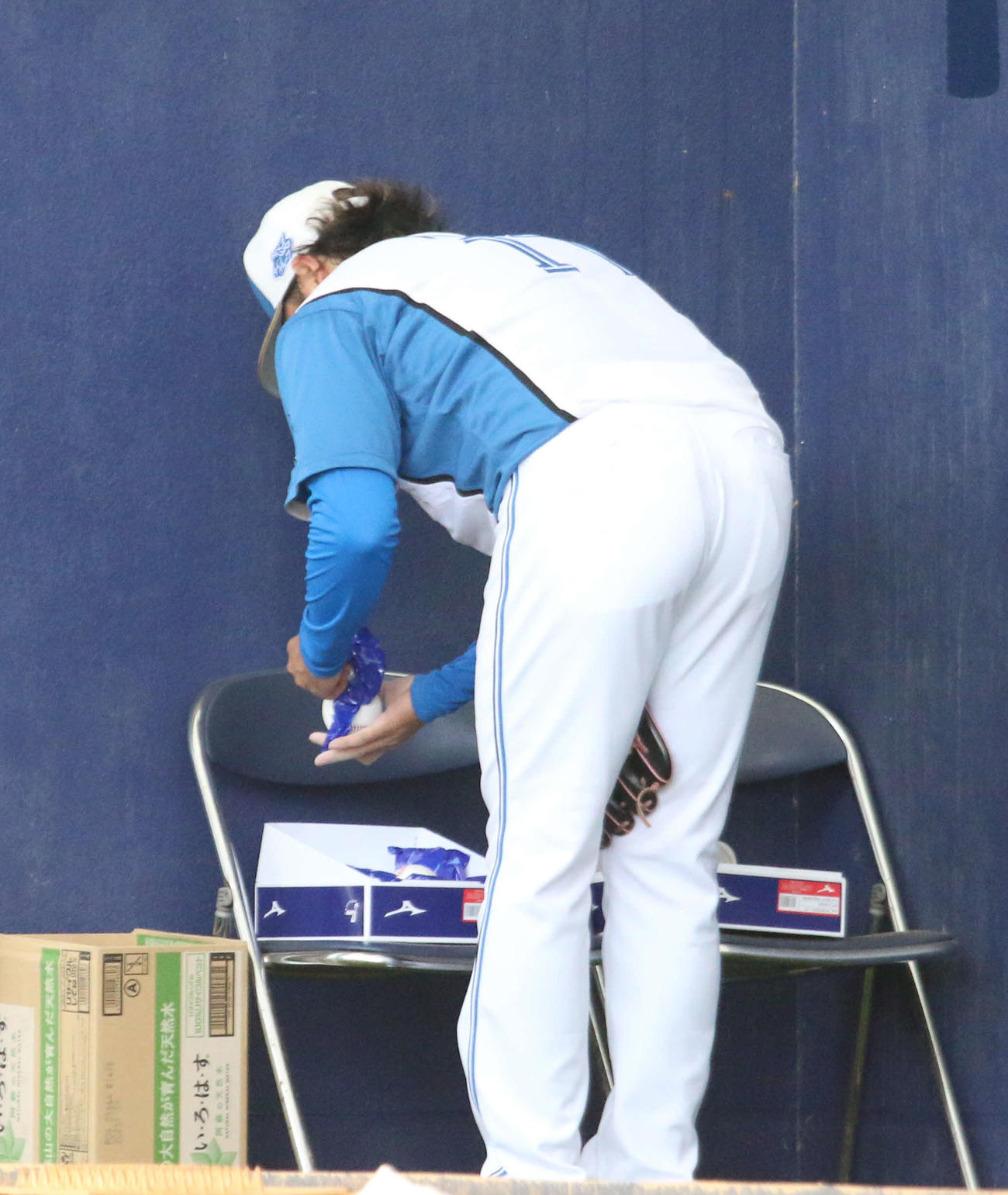 名護キャンプでブルペン入りし、途中で新球を取り出す日本ハム伊藤（撮影・木下大輔）