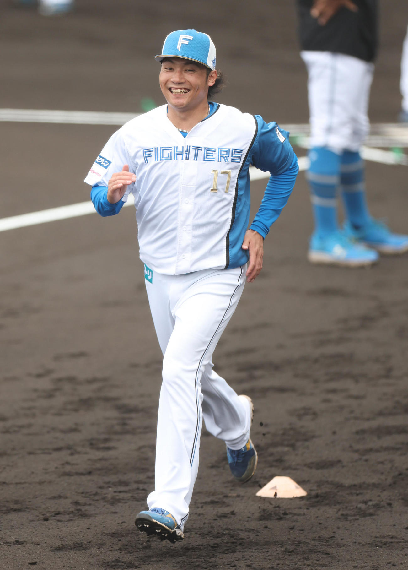笑顔でダッシュをする日本ハム伊藤（撮影・佐藤翔太）