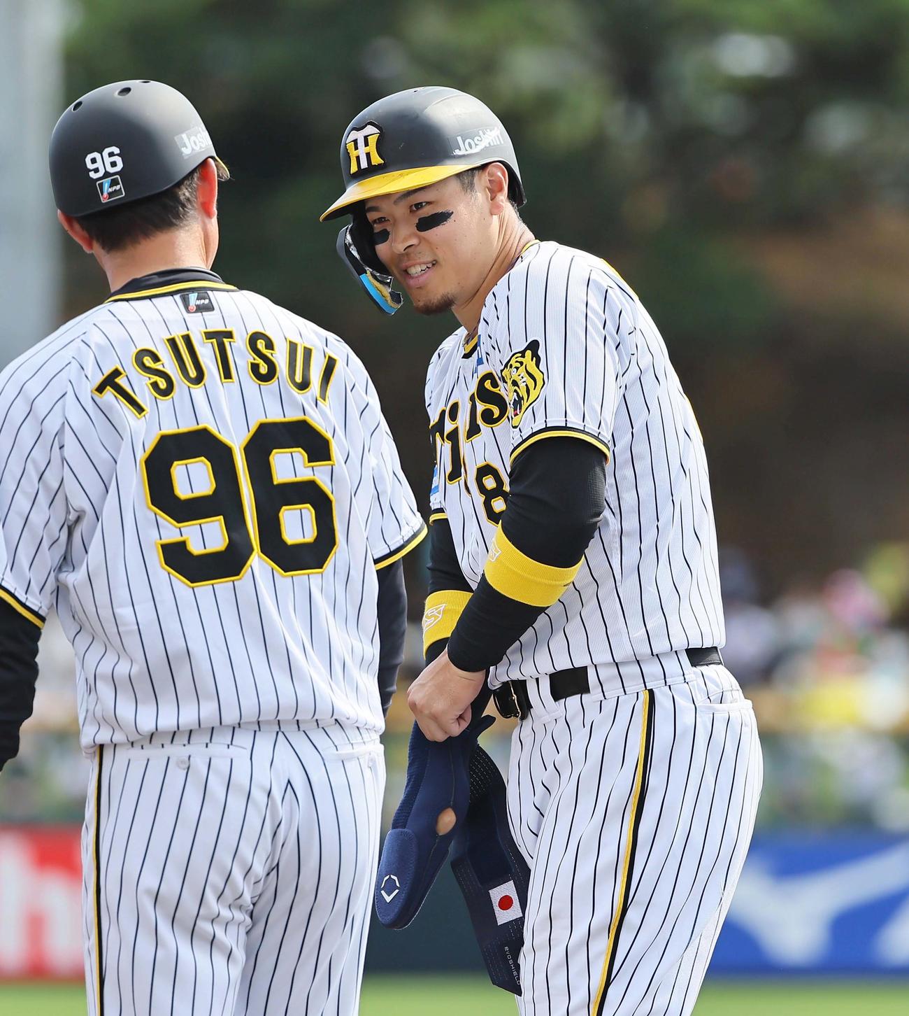 阪神対楽天　4回裏阪神1死一、二塁、左前に適時打を放った佐藤輝は笑顔を見せる。走塁ガード手袋には日の丸（撮影・上田博志）