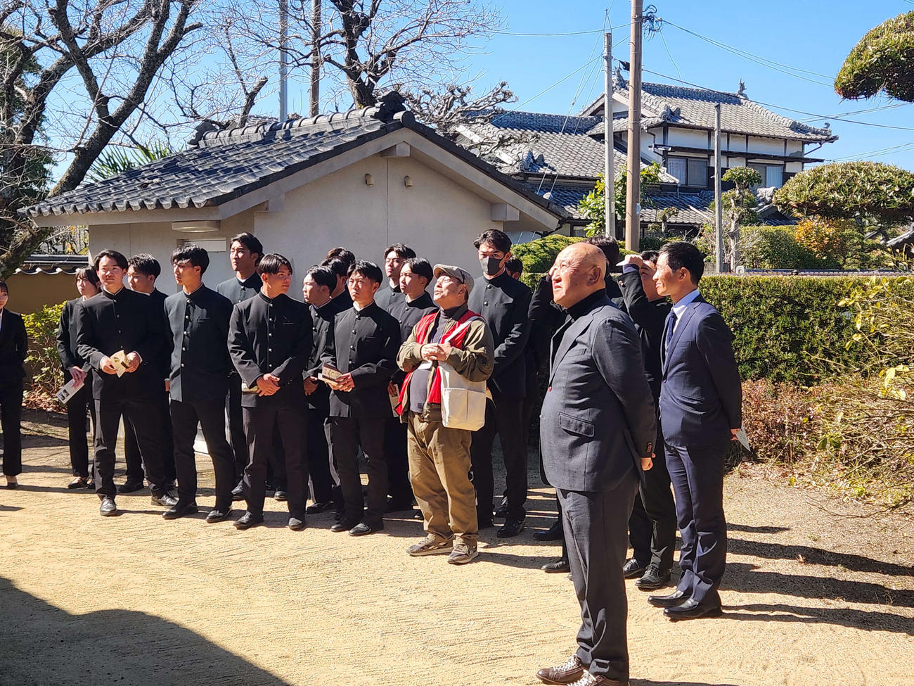 大分県の中津合宿初日。慶応の創始者である福沢諭吉の旧居を見学し、観光ガイドの説明を熱心に聞く慶大の堀井哲也監督と選手たち（撮影・保坂淑子）