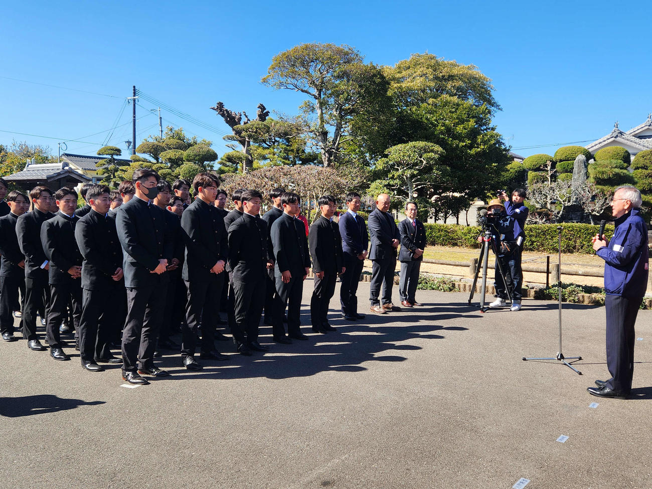 大分県の中津合宿初日。福沢諭吉の旧居前での歓迎セレモニーで、奧塚正典市長の歓迎のあいさつを聞く、慶大の選手とスタッフ（撮影・保坂淑子）