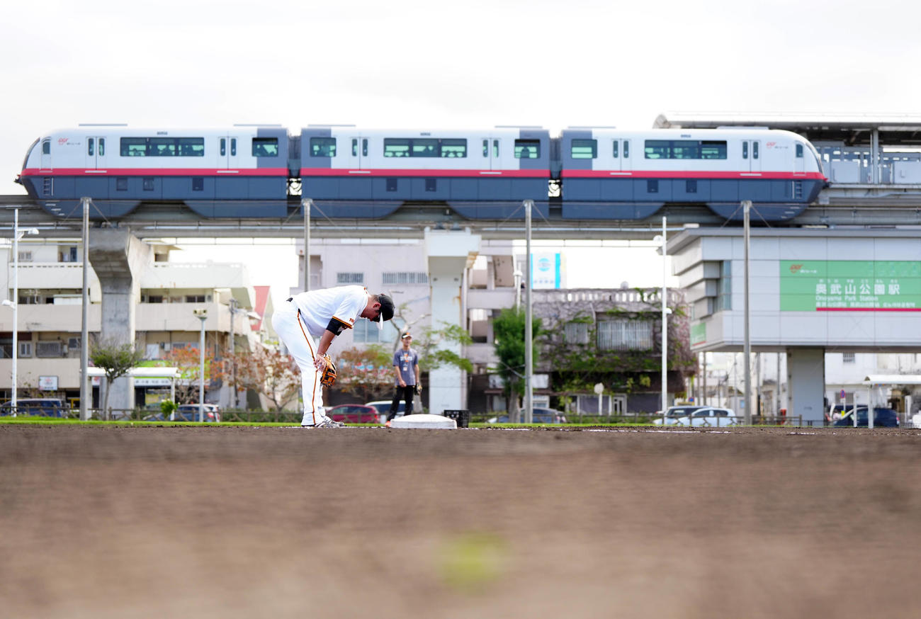 サブグラウンドでノックを受ける巨人坂本。後方は沖縄都市モノレールの「ゆいレール」（撮影・江口和貴）