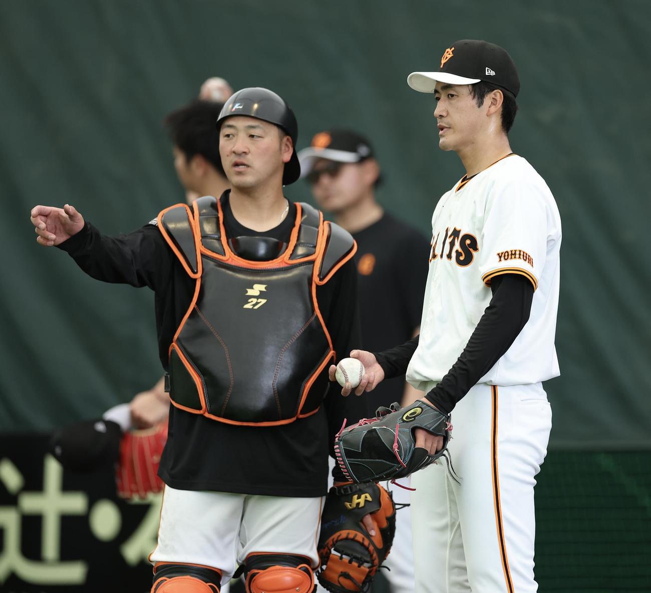 ブルペンで岸田（左）と言葉を交わす巨人西舘（撮影・河田真司）