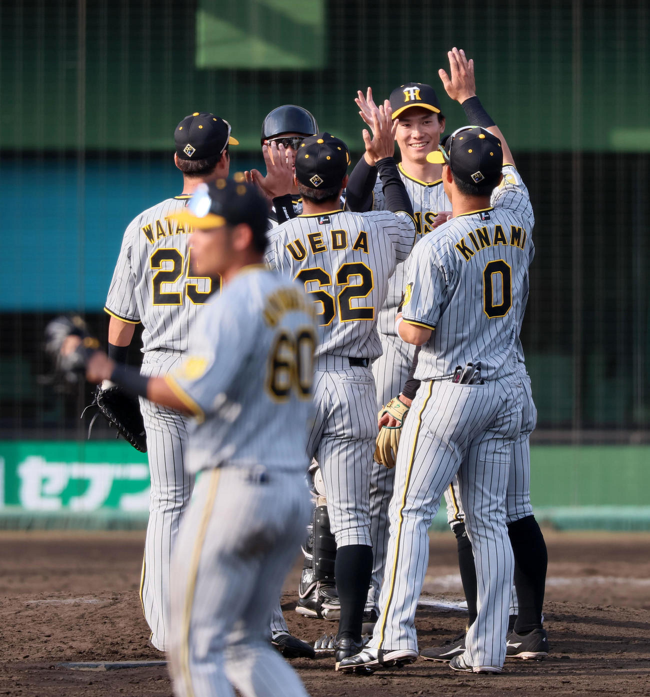 練習試合　広島対阪神　広島に勝利し笑顔でナインとタッチする湯浅（撮影・加藤哉）