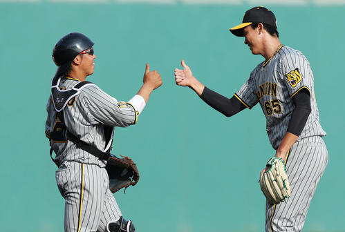 広島対阪神 広島に勝利し、タッチを交わす阪神梅野(左)と湯浅(撮影・前田充)