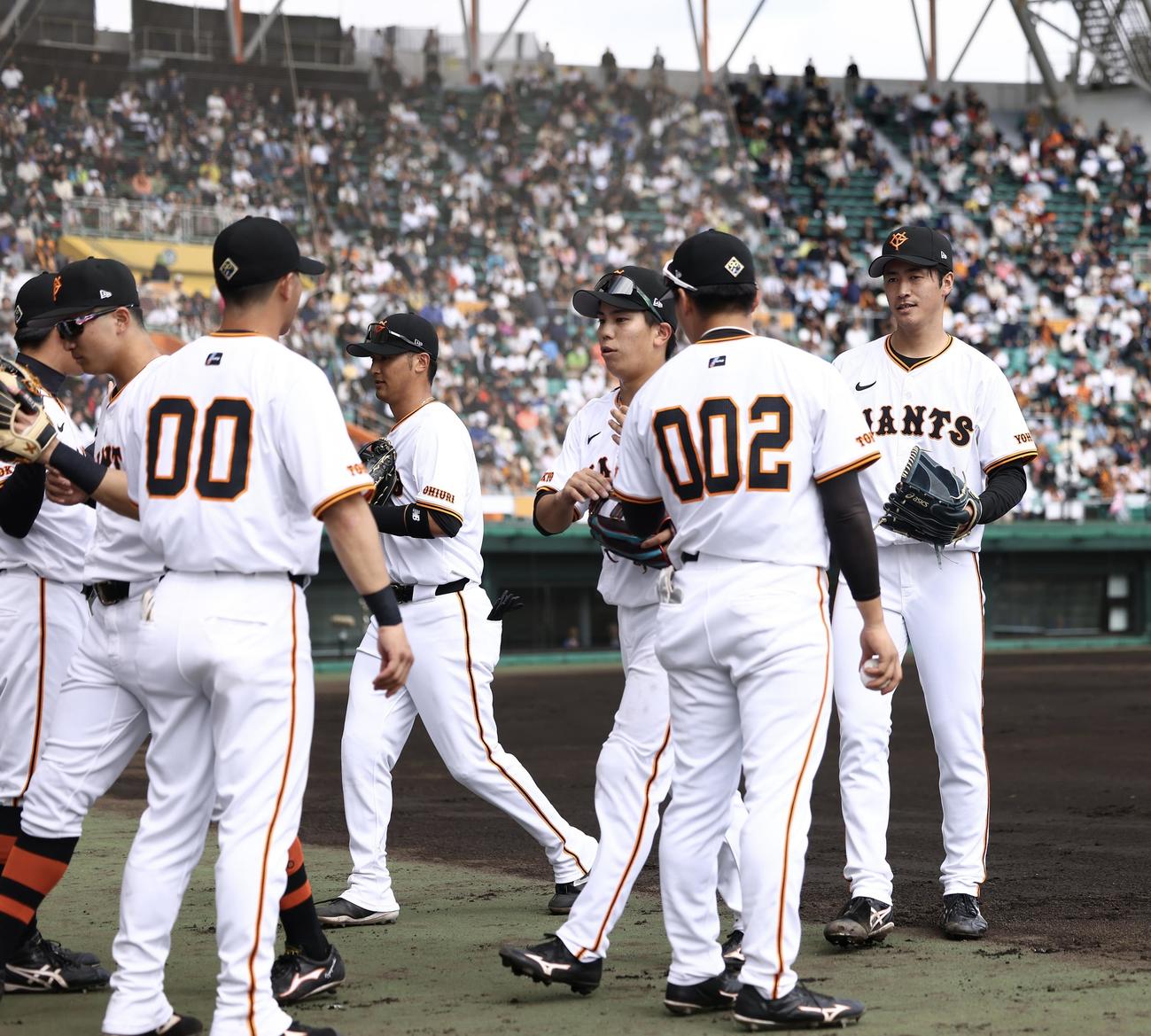 巨人対サムスン　2回表を抑え、ナインを迎える西舘（右）（撮影・河田真司）