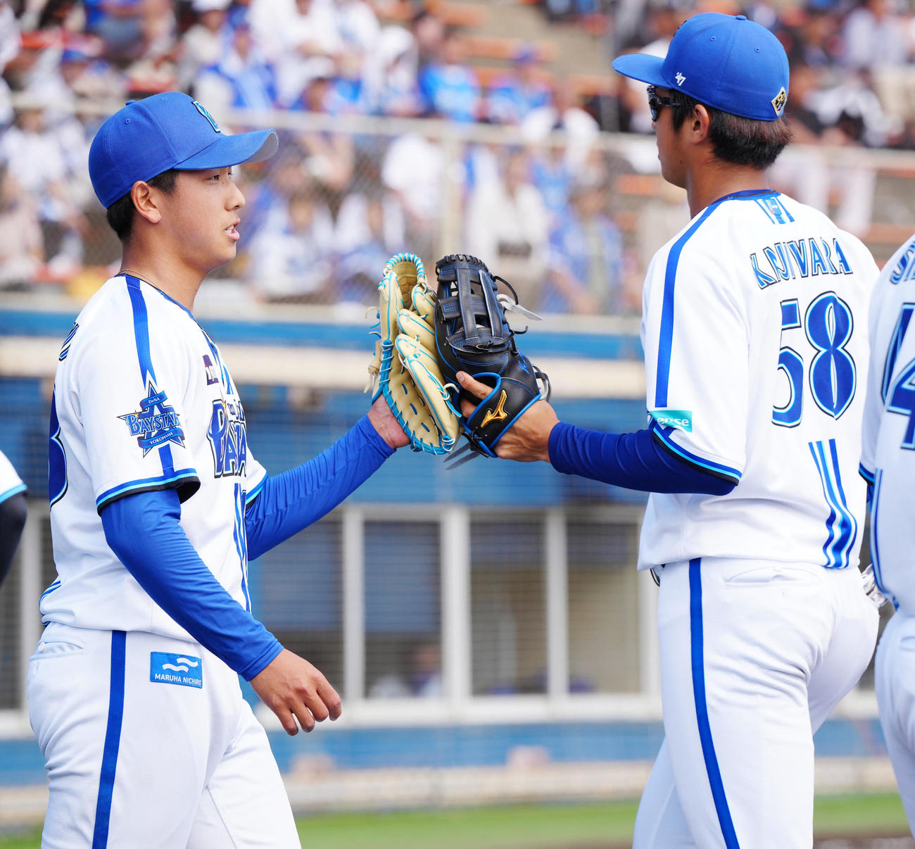 DeNA対ロッテ　5回表終了後、DeNA梶原（右）とタッチを交わす2番手の深沢（撮影・江口和貴）