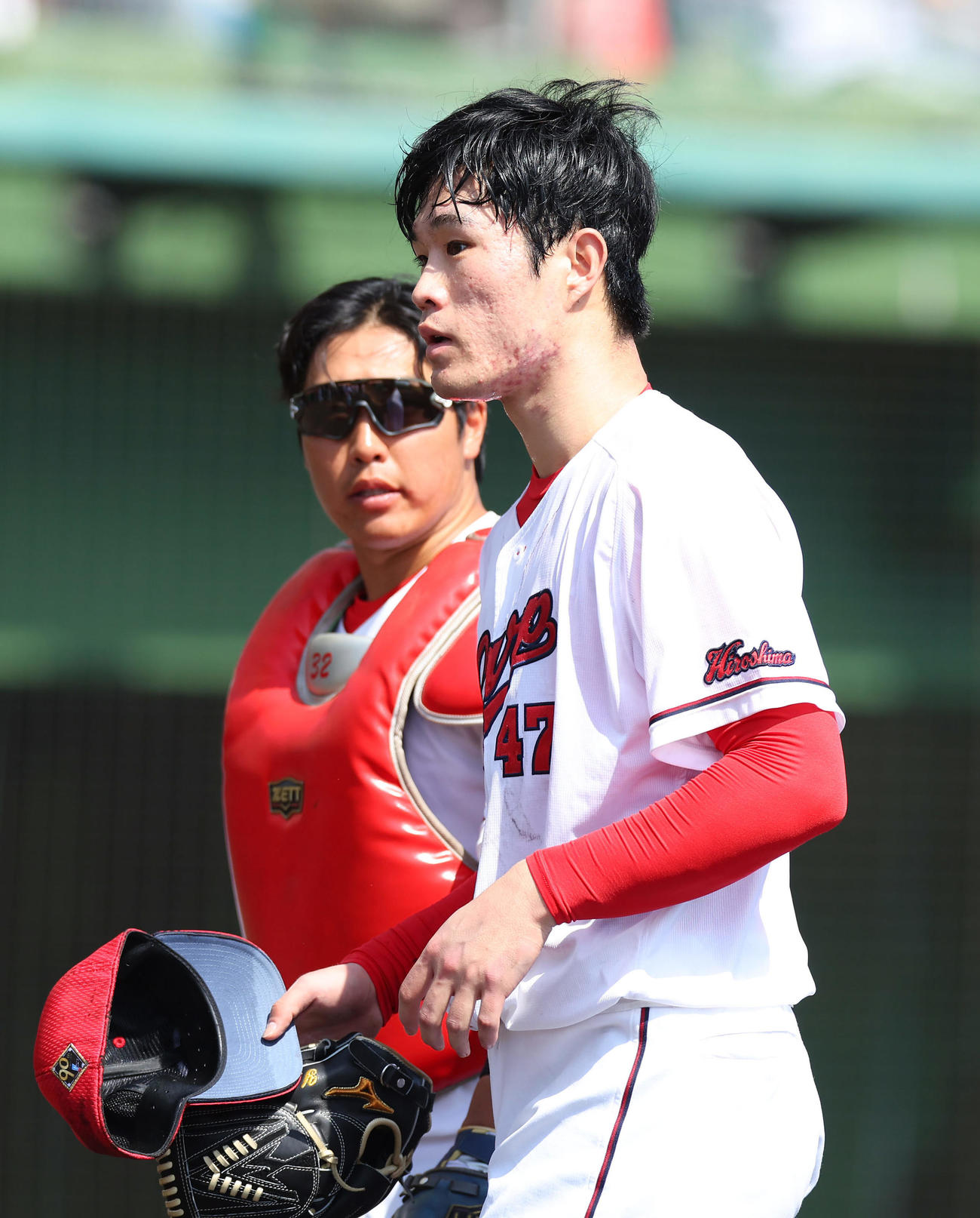 広島対阪神　1回表を投げ終えベンチへ戻る広島斉藤。左は石原（撮影・前田充）