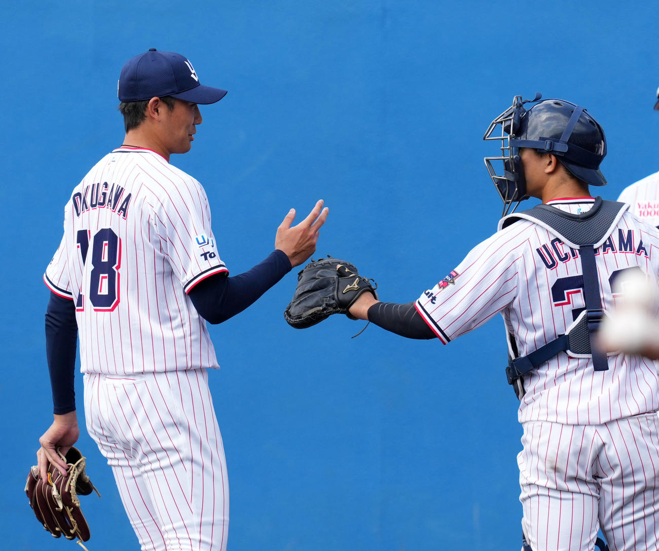 ヤクルト対中日　1回表を無失点に抑えタッチを交わすヤクルト奥川（左）と内山（撮影・横山健太）