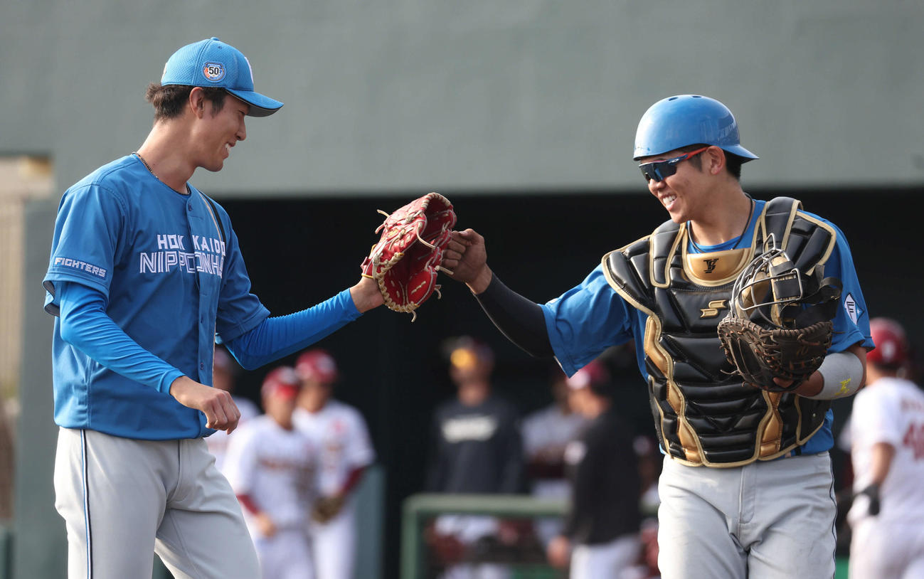 楽天対日本ハム　8回裏を無失点に抑えタッチをする日本ハム福島（左）と清水（撮影・佐藤翔太）