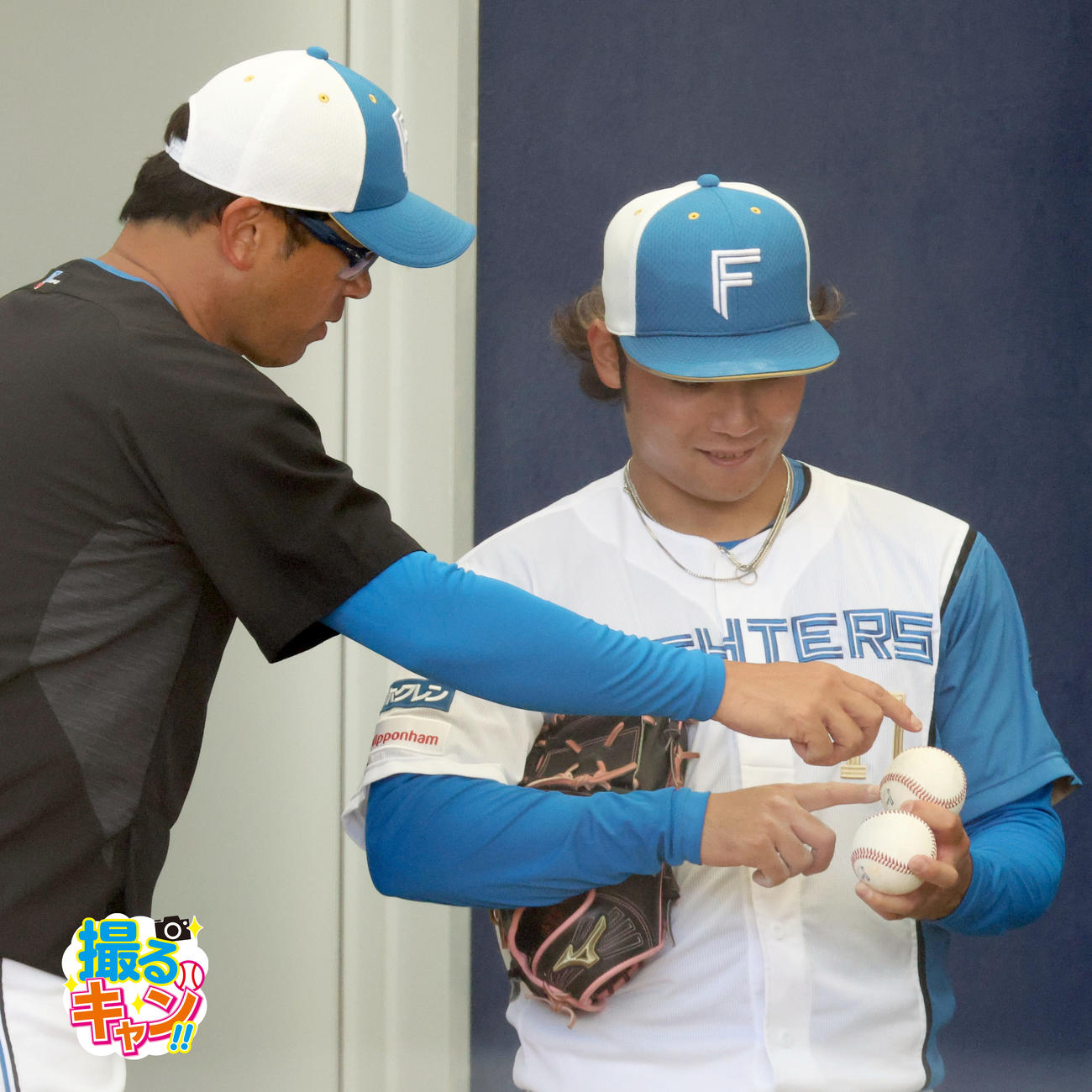 ブルペンでボールを見つめる日本ハム建山コーチ（左）と伊藤（撮影・佐藤翔太）