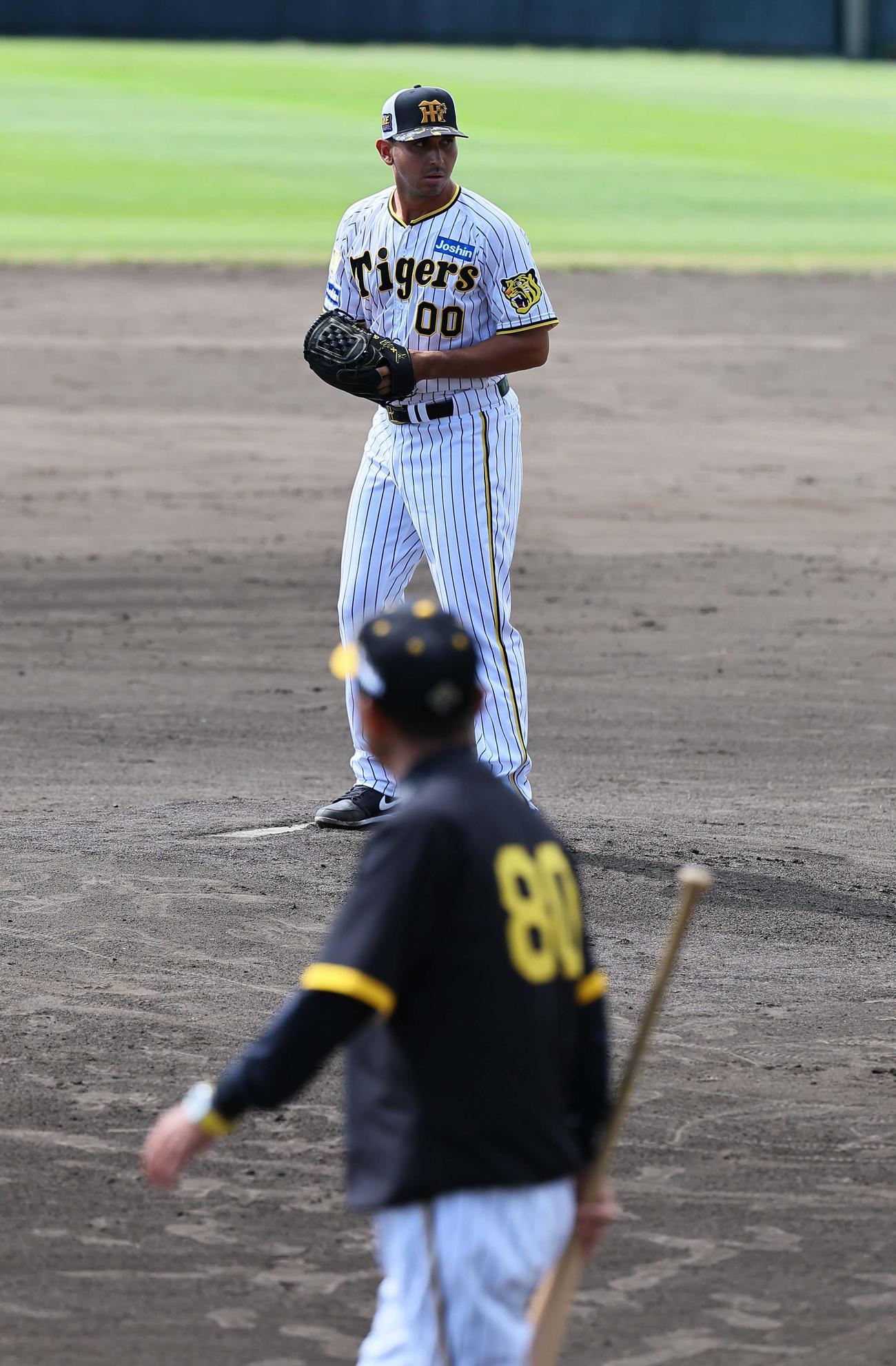 岡田監督（手前）のチェックを受けながら投球練習をするゲラ（撮影・上田博志）