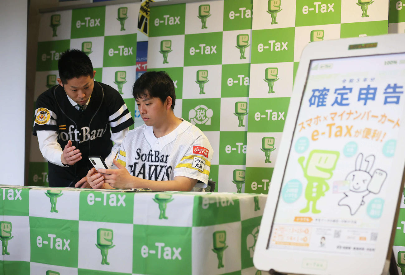 スマホでの確定申告書作成を体験するソフトバンク大関（撮影・冨田成美）