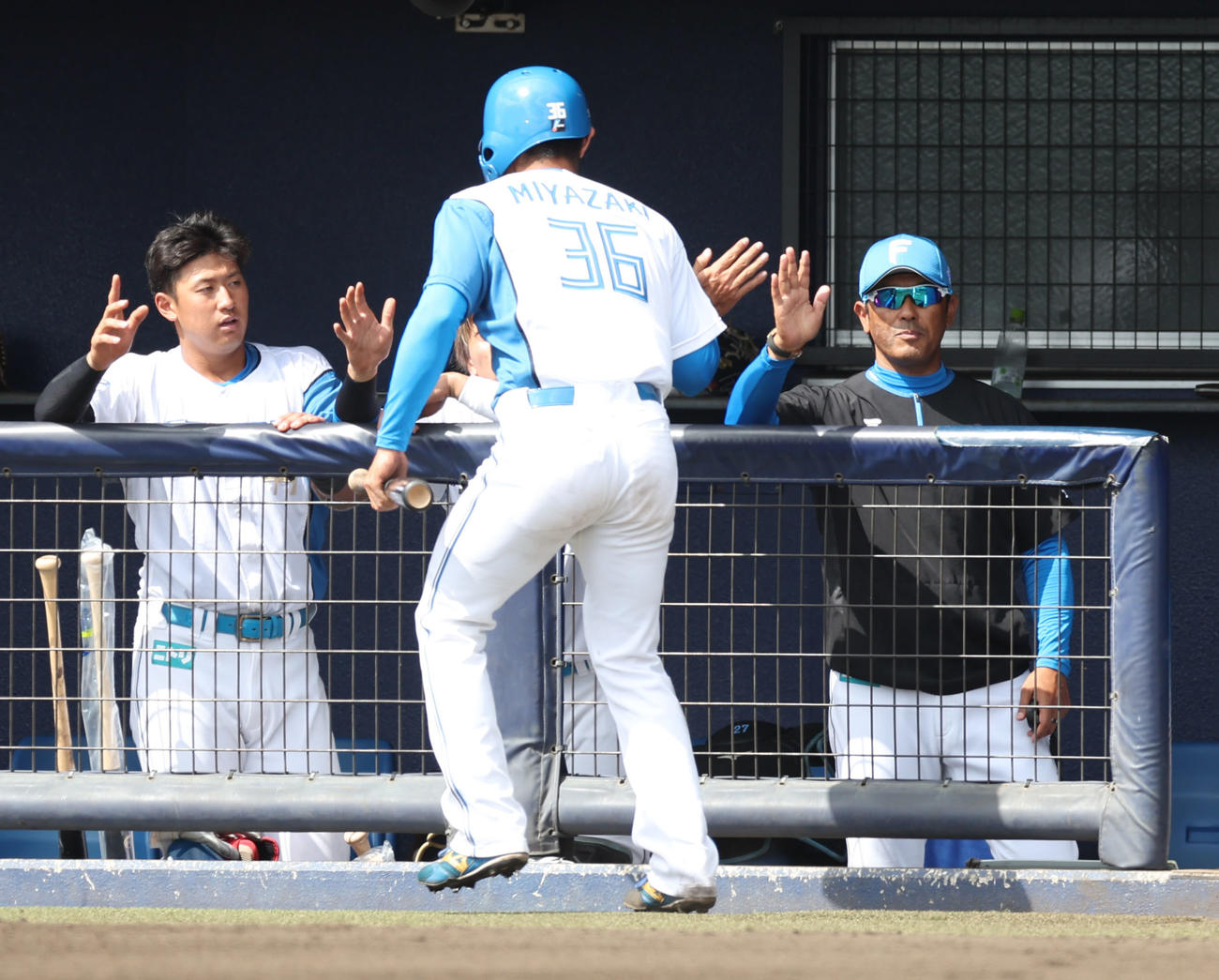 日本ハム対サムスン　1回裏日本ハム無死一、三塁、浅間の左前適時打で生還する宮崎を出迎える稲葉2軍監督（右）（撮影・佐藤翔太）