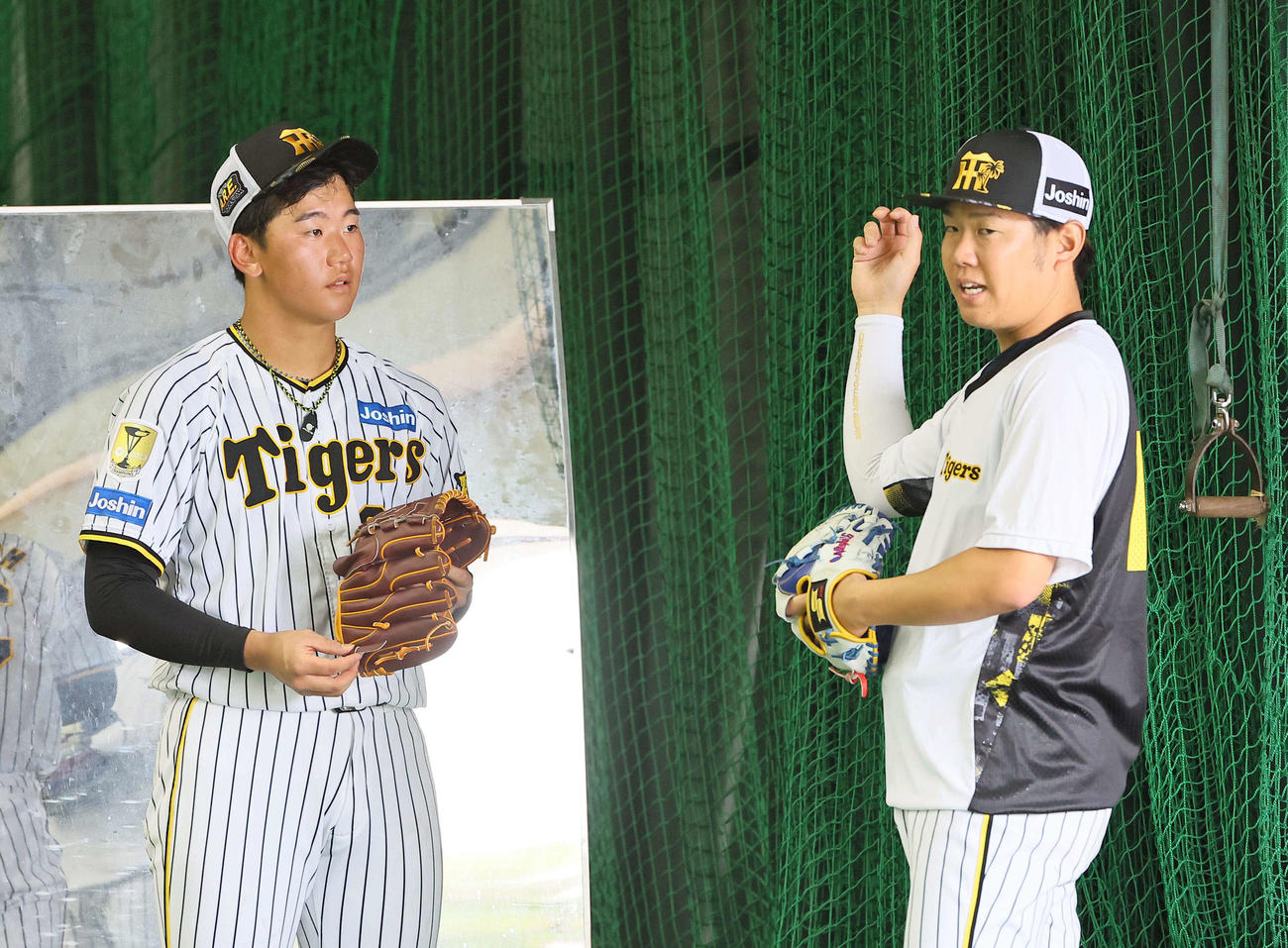 西勇輝（右）からアドバイスを受ける門別（撮影・上田博志）