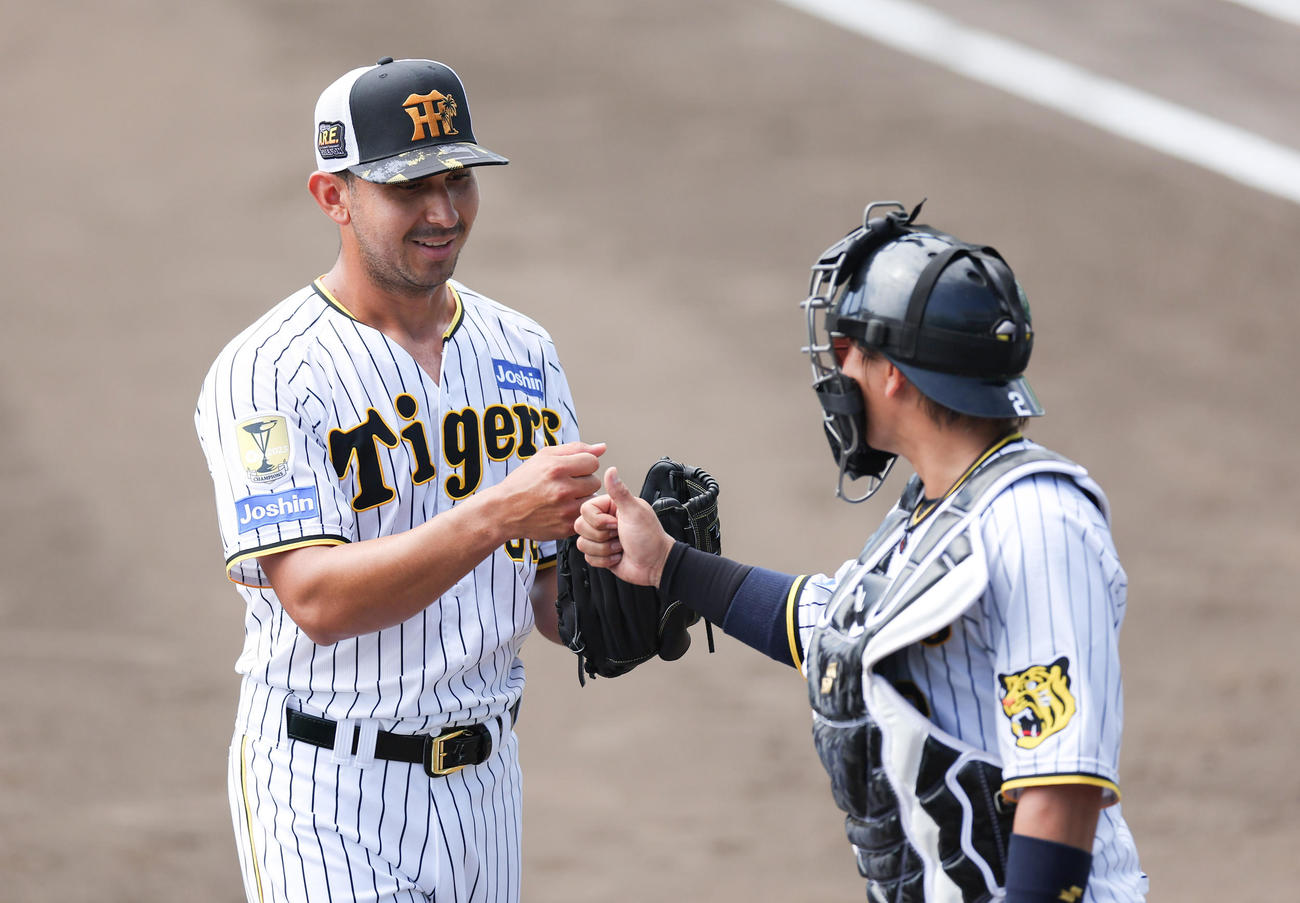 阪神春季キャンプ　ランチ特打で打撃投手を務め、阪神梅野（右）とグータッチを交わすゲラ（撮影・前田充）