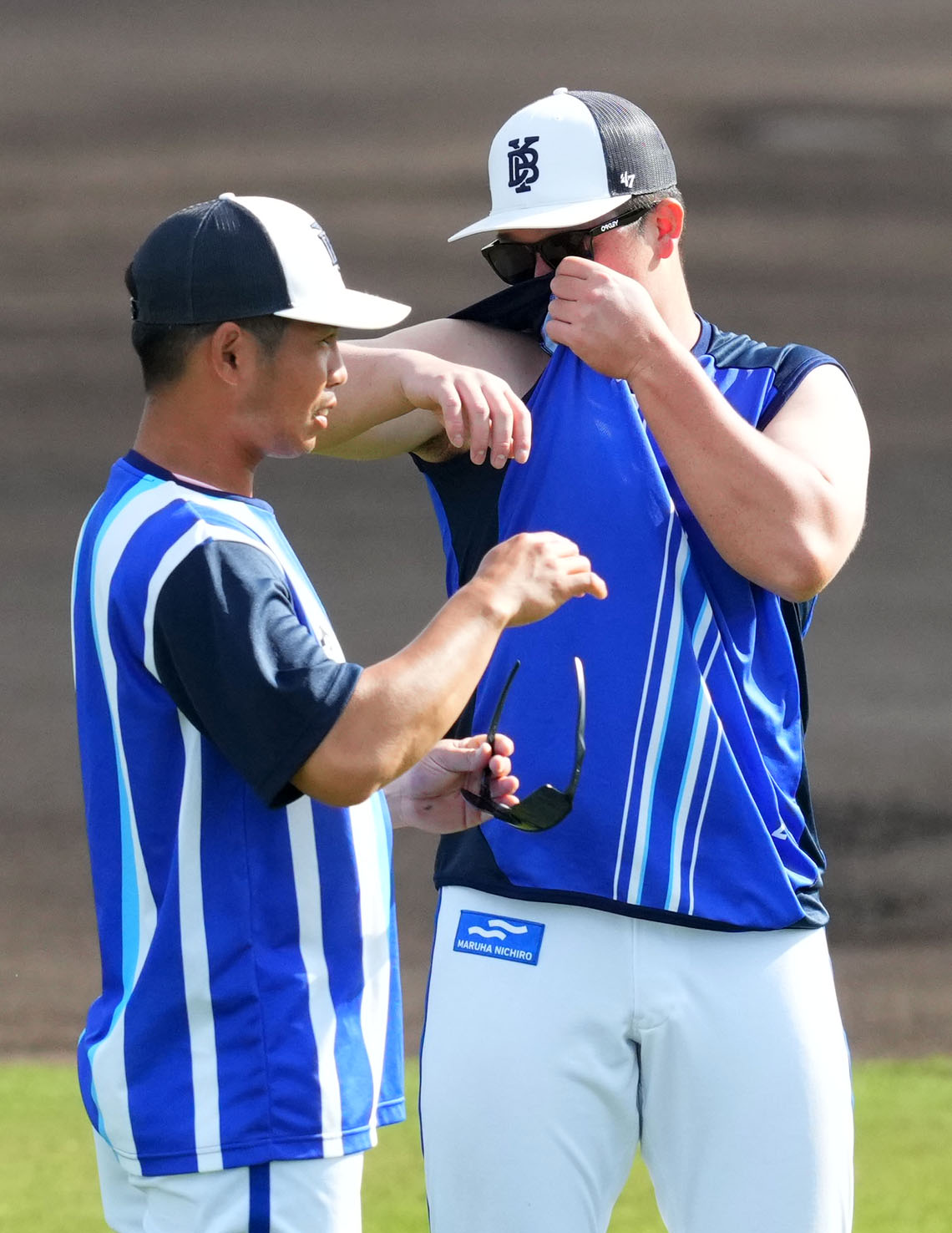 練習開始前、自身のシャツのにおいをかぐDeNA牧（右）（撮影・横山健太）