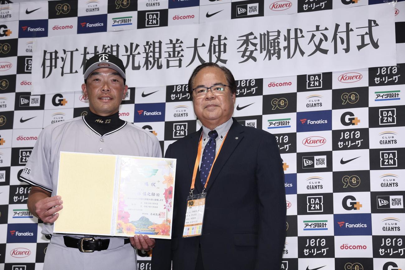 伊江村観光親善大使の巨人阿部監督（左）は、名城村長から委嘱状を受け取る（撮影・河田真司）