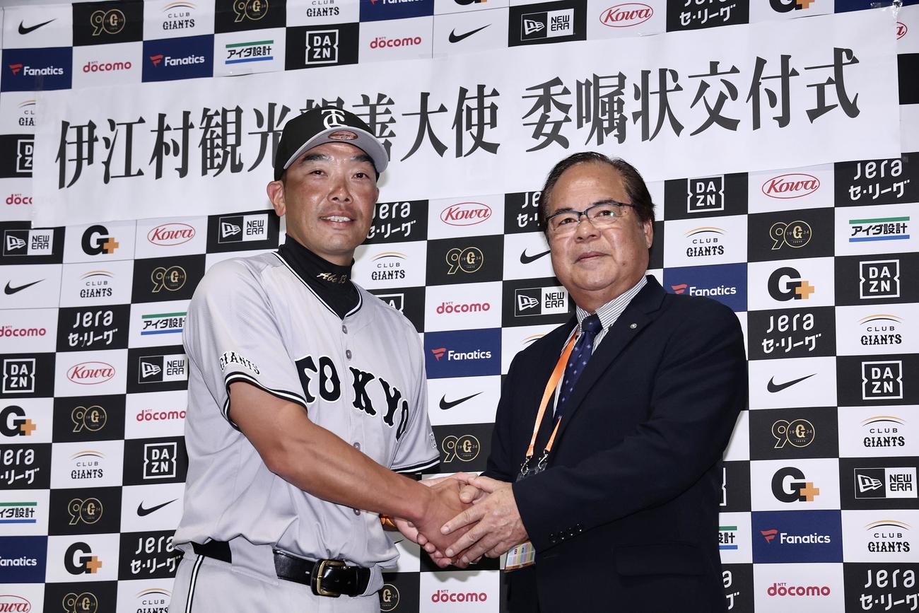 委嘱状交付式で握手を交わす、伊
江村観光親善大使の巨人阿部監督（左）と名城村長（撮影・河田真司）