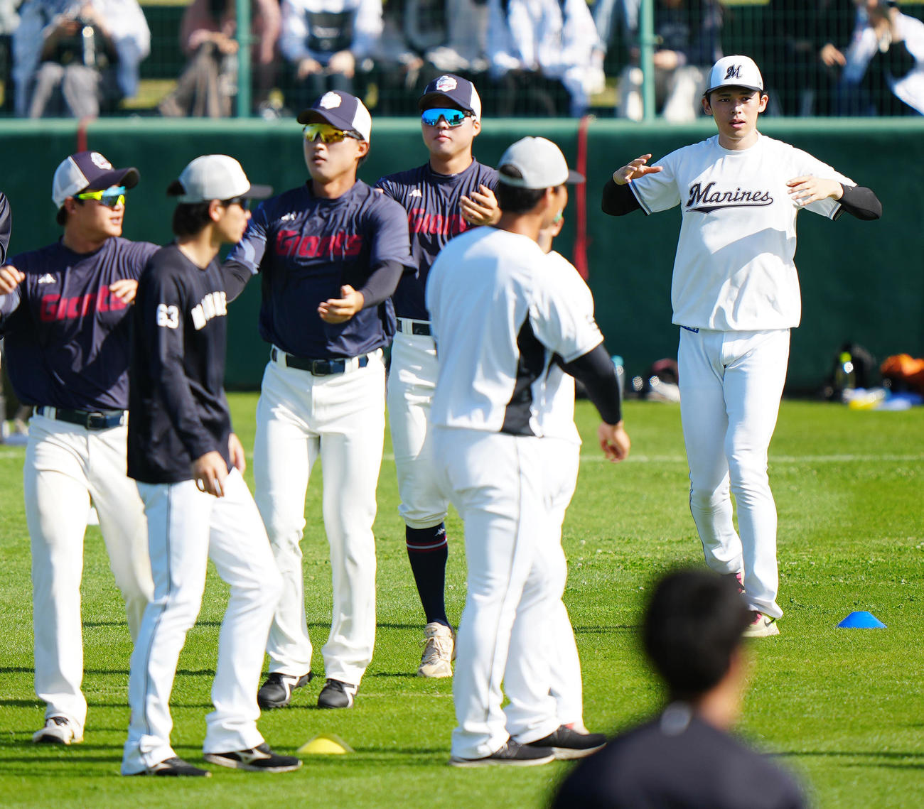 韓国ロッテの選手たちとウオーミングアップを行うロッテ佐々木（右端）ら（撮影・江口和貴）