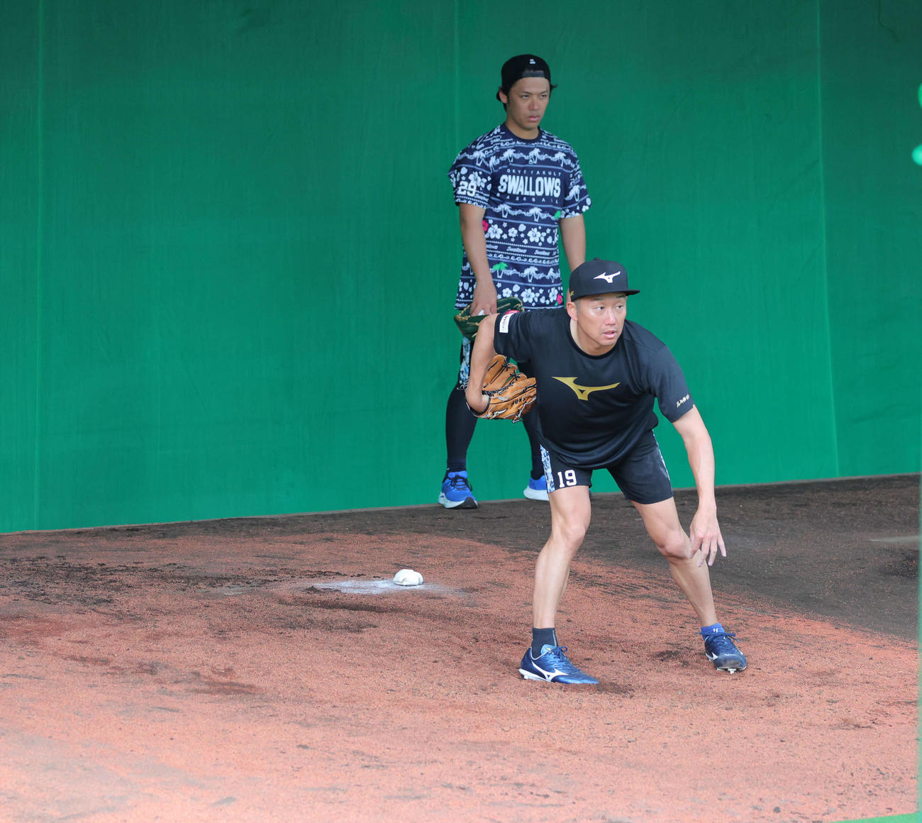 ヤクルト小川が背後で見つめる前でブルペンで調整する石川