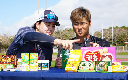お菓子を食べ比べするロッテ山口(右)と韓国ロッテの金元中(撮影・江口和貴)
