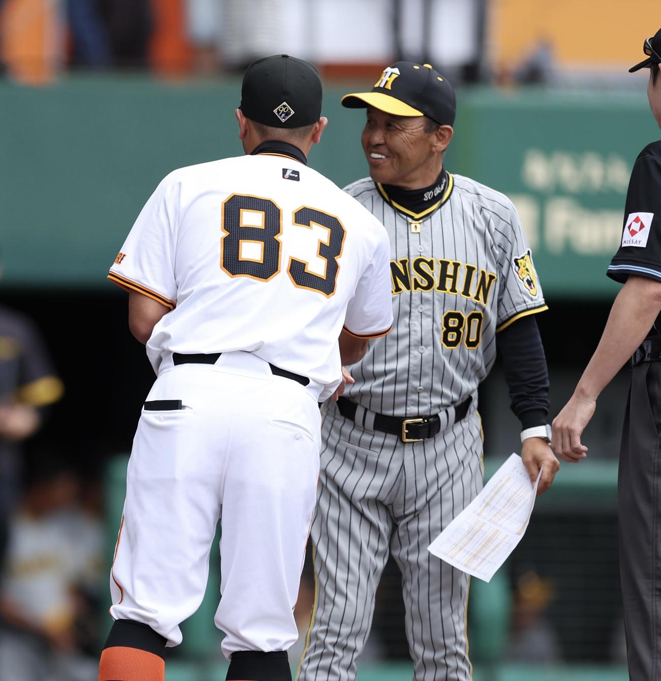 巨人対阪神　開始前、メンバー表交換で巨人阿部監督（手前）とあいさつを交わす阪神岡田監督（撮影・河田真司）